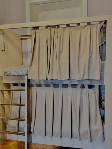 a bunk bed with curtains in a room at Hifzas Hostel in Baku