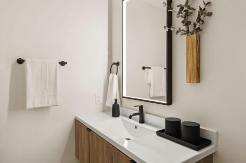 Un baño con lavabo, espejo y toallas. en Tide House - Unit D - Modern Oceanview 1BD w Parking, en El Segundo