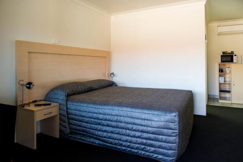 Ένα ή περισσότερα κρεβάτια σε δωμάτιο στο Cherry Blossom Motor Inn