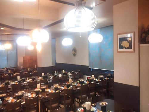 a large dining room with tables and chairs and lights at Hotel Kaanapali in Shirako