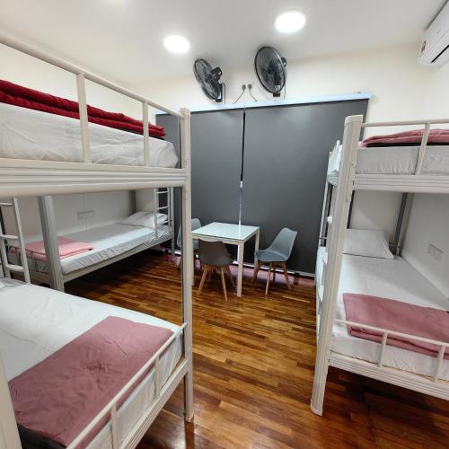 a room with three bunk beds and a table at VnV DORM HOMESTAY in Shah Alam