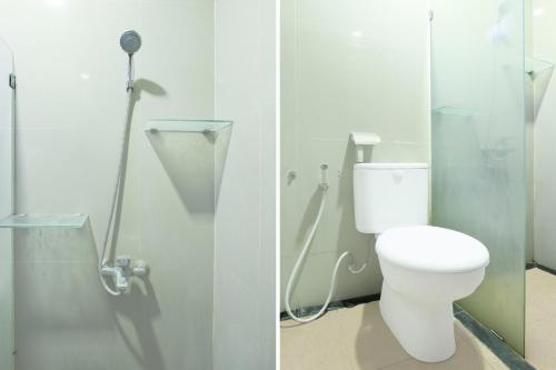 ein Badezimmer mit Toilette und Duschkabine in der Unterkunft Hotel O Rumah Daun Guesthouse Jogja in Demangan