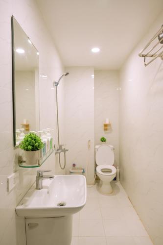 a white bathroom with a sink and a toilet at The Hideout Stay in Hanoi