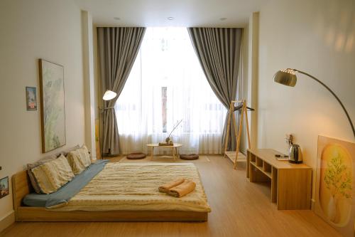 ein Schlafzimmer mit einem Bett und einem großen Fenster in der Unterkunft The Hideout Stay in Hanoi