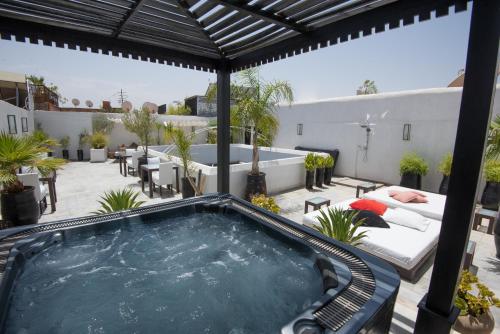 a large pool of water surrounded by a patio area at Riad Villa Wengé & Spa in Marrakesh