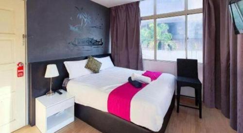 a bedroom with a bed and a chair and a window at OYO 90106 Sindbad Hotel in Kuala Lumpur