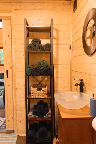 a bathroom with a sink and a shelf with towels at Chatka na Wiedźmiej Górce in Kuttlau