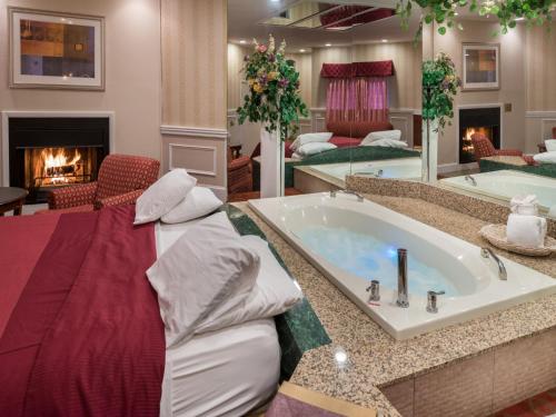 a large bathroom with a tub with a fireplace at Inn of The Dove Romantic Luxury & Business Suites in Bensalem
