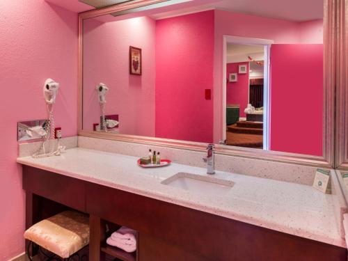 a bathroom with a sink and a large mirror at Inn of The Dove Romantic Luxury & Business Suites in Bensalem