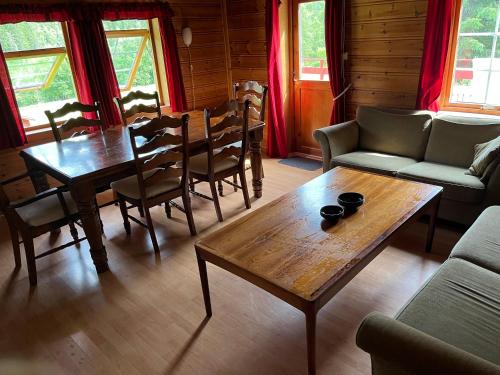 a living room with a table and chairs and a couch at Døskelandslia Camping in Sygna