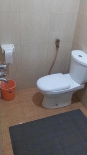 a bathroom with a white toilet in a room at Pendopo Andari Homestay in Yogyakarta