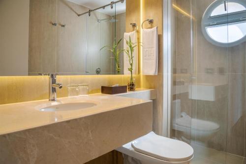 Un baño con lavabo, inodoro y ducha. en NH Boulevard del Río Cali, en Cali