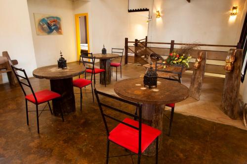 a restaurant with tables and chairs with red seats at Pousada Província in Lavras Novas