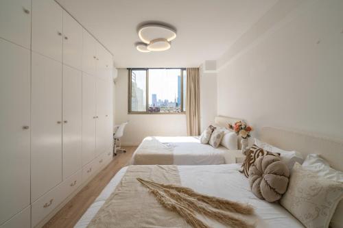 ein weißes Schlafzimmer mit zwei Betten und einem Fenster in der Unterkunft HuanYu in Shanghai