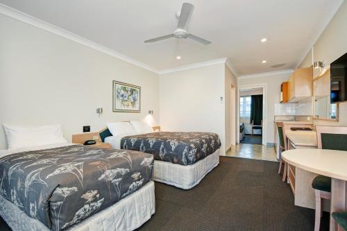 a hotel room with two beds and a kitchen at Colonial Terrace Motor Inn in Raymond Terrace