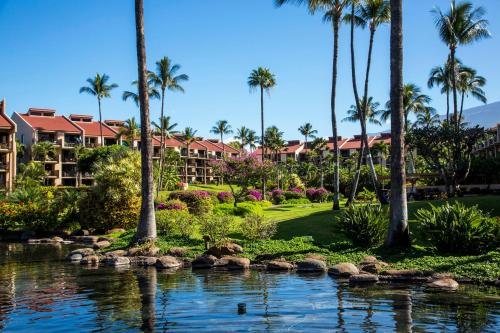 a view of a resort with palm trees and a pond at Castle Kama'ole Sands in Wailea