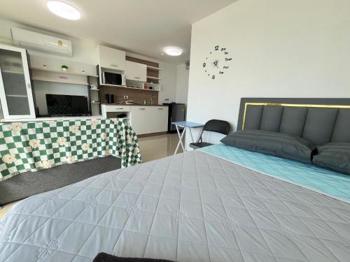 a bedroom with a large bed and a kitchen at Bangsaray Beach B414 บางเสร่ บีช รายเดือน in Bang Sare
