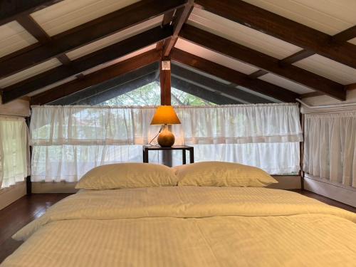 a bedroom with a large bed with a window at Rain Tree Country Home in Bukit Mertajam