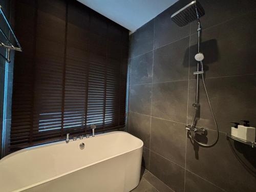 a bathroom with a bath tub and a shower at Sann Boutique Nan in Nan