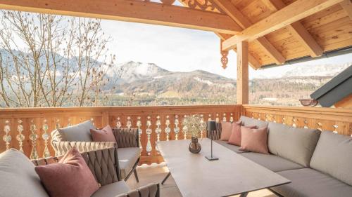 eine abgeschirmte Veranda mit Sofas und einem Tisch in der Unterkunft Sunleitn-Residenz in Bad Goisern