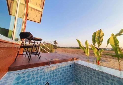 a patio with a table and a chair next to a pool at Fang Chayapa Hotel in Fang