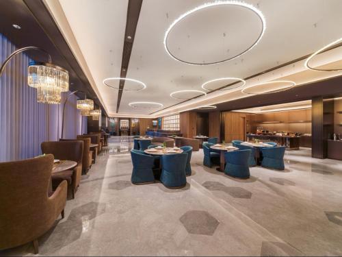 上海上海虹桥机场国展中心桔子水晶酒店的餐厅设有蓝色的桌椅和吊灯。