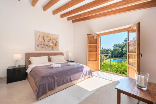 a bedroom with a bed and a large window at Can Perot - Pollença in Pollença
