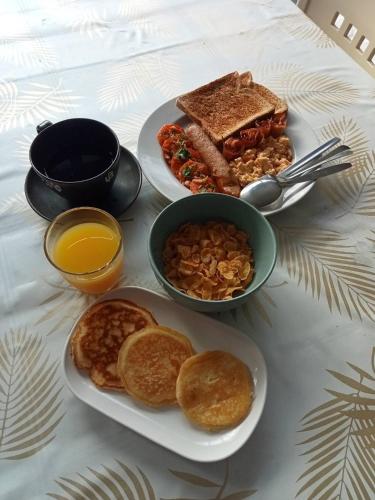 a table with two plates of breakfast food and toast at Amadha Villas Retreat - Free Tuk-Tuk Service To the Beach in Ao Nang Beach