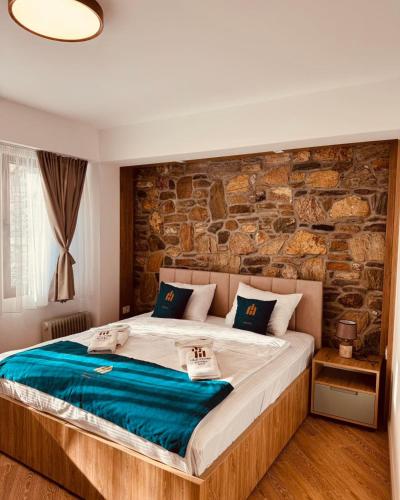 a bedroom with a large bed with a stone wall at Old Stone Hotel Skopje in Skopje
