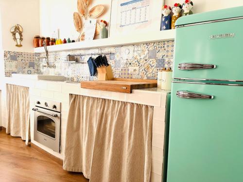 cocina con nevera azul y fogones en ComeCasa Langhe Garden House-Pace e Panorama a Benevello, en Benevello