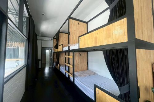 a room with two bunk beds in a house at Lazy Lizard Hostel in Ban Nong Chaeng