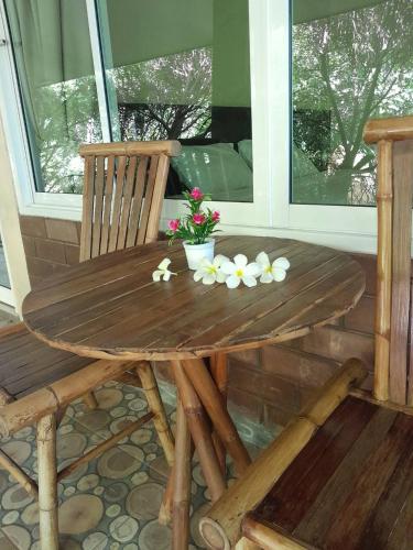 a wooden table with flowers on a porch at Samran Resort in Chalong