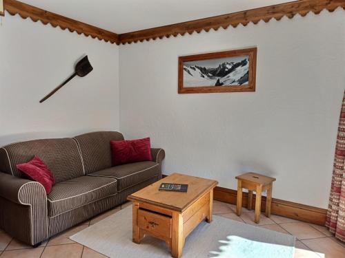 ein Wohnzimmer mit Sofa und Tisch in der Unterkunft Au cœur de Chamonix, La Ginabelle, Calme avec Piscine, Sauna et Garage in Chamonix-Mont-Blanc