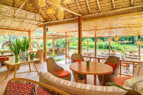 a restaurant with a table and chairs and tables and chairs at The Riverfront Reserve in Pai