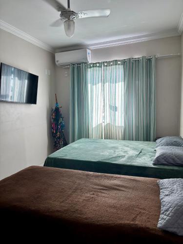 a bedroom with a large bed with a window at Suíte férias in Cabo Frio