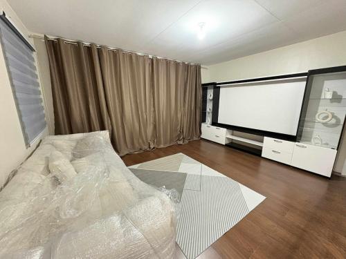 a living room with a bed and a flat screen tv at Solana Zaragoza house for lease in Capaya