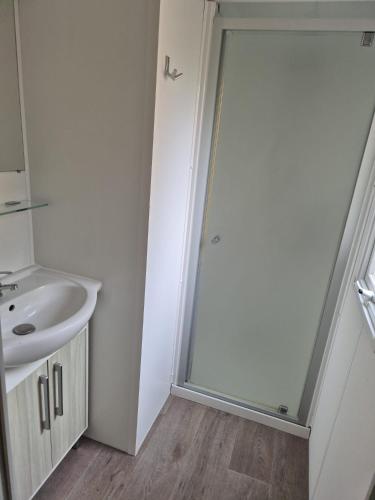 a bathroom with a shower and a sink at Vias plage "MER & SOLEIL" Mobil home camping La Carabasse 6 a 8 personnes in Vias