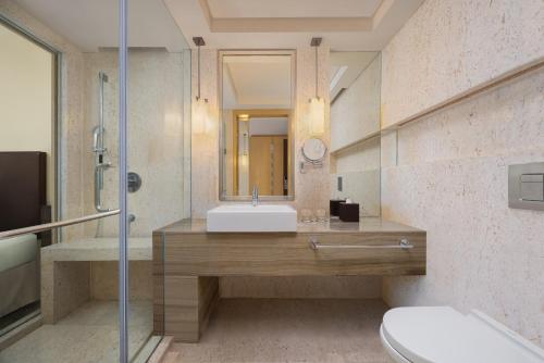a bathroom with a sink and a mirror at Courtyard by Marriott Bilaspur in Bilāspur