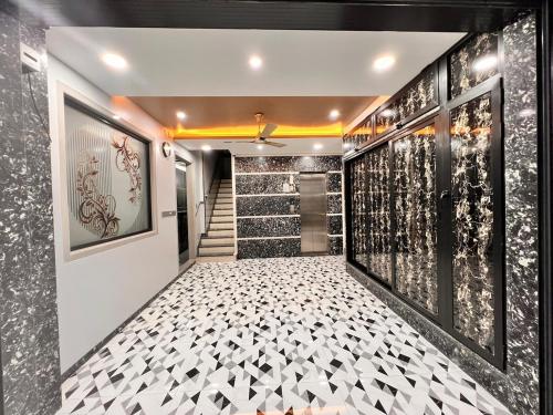 Un pasillo con suelo de baldosas blancas y negras y escaleras. en Newtown Inn Service Apartment, en Hulhumale