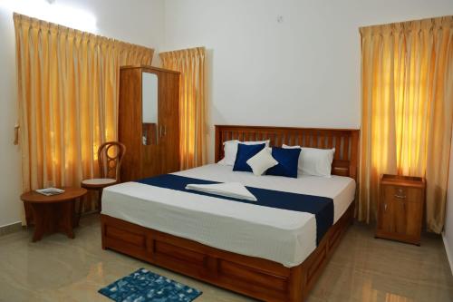 a bedroom with a large bed with blue pillows at Rain Drops Homestay in Anachal
