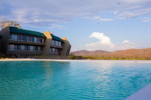 a building with a pool of water in front of it at Wellworth Mikumi Wildlife Lodge in Morogoro