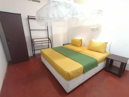 a bedroom with a bed with yellow and green sheets at Apartment no17 in Galle