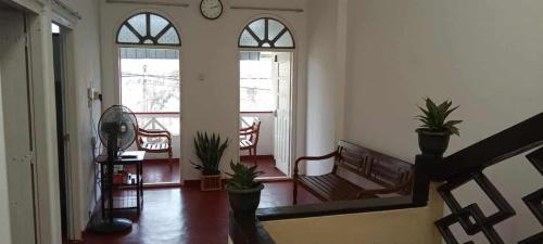 a hallway with a bench and potted plants and windows at Apartment no17 in Galle