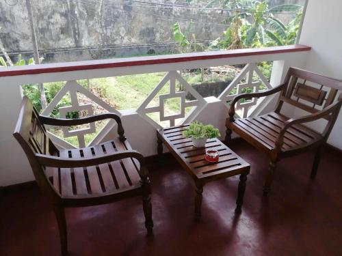 three chairs and a table in front of a window at Apartment no17 in Galle