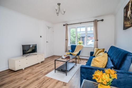 a living room with a blue couch and a tv at Fowler House 2 Bedroom ,Free WIFI, Parking, Crawley, Close to Gatwick Airport, Contractor friendly, business travellers in Three Bridges