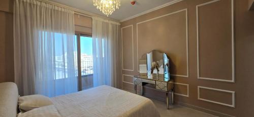 a bedroom with a bed and a mirror and a window at Peaceful Apartments in Dubai