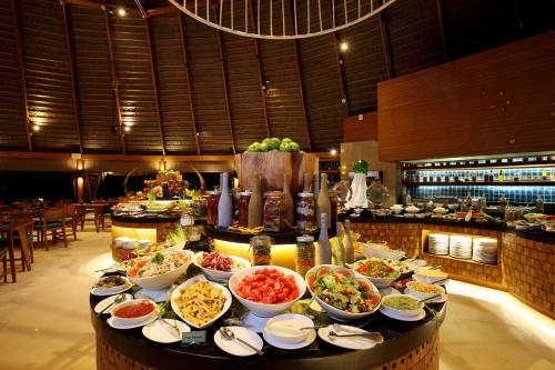 a buffet with many bowls of food on a table at Centara Ras Fushi Resort & Spa Maldives - 50 percent discount on transfers for min 4 nights stay and more, valid for reservations between 11th Feb till 22 Dec 2025 in North Male Atoll