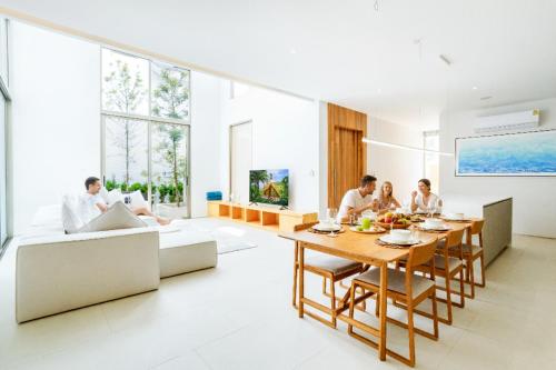 a group of people sitting around a table in a living room at Elite Living - Design 3BR Pool Villa in Newly Built LuxPride 4 L6 Residence in Bang Tao Beach