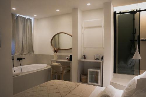 un bagno con vasca, lavandino e specchio di San Michele Rooms & Private Spa - via Santa Cesarea a Matera