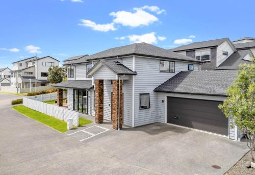 a house with a garage in a residential neighborhood at Long Bay Breeze Ensuite in Auckland